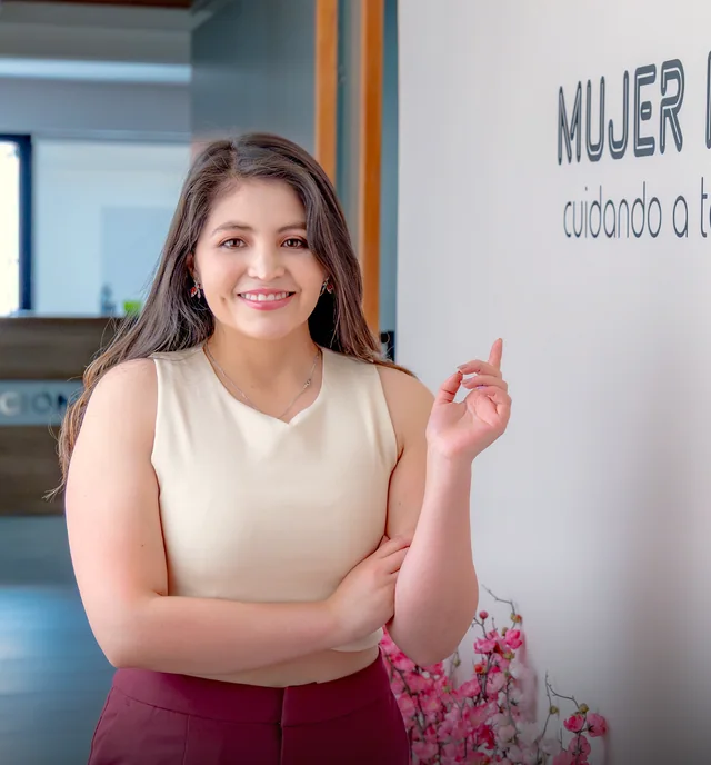 La Dra. Camila León en el Centro Médico Mujer Integral, ante el muro con el nombre del Centro.